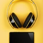 Close up yellow headphones and mobile phone